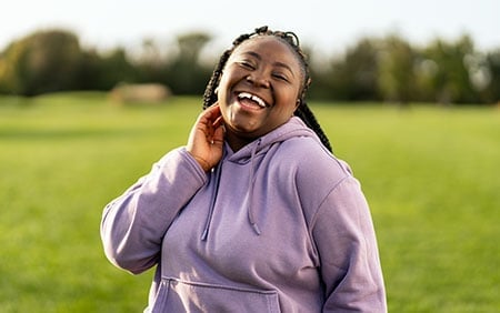 Smiling African American woman outdoors who started thyroid hormone optimization for her health