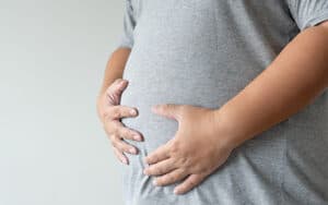 Close up of overweight man holding his belly